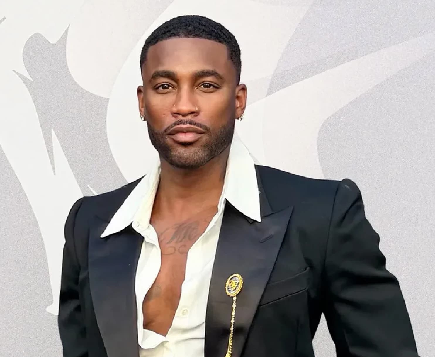 Kellon Deryck posing in a black suit at an event