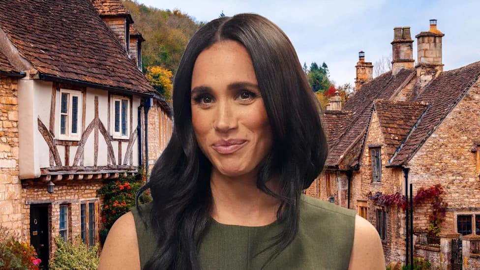 Meghan Markle smiling in front of Cotswolds stone cottages