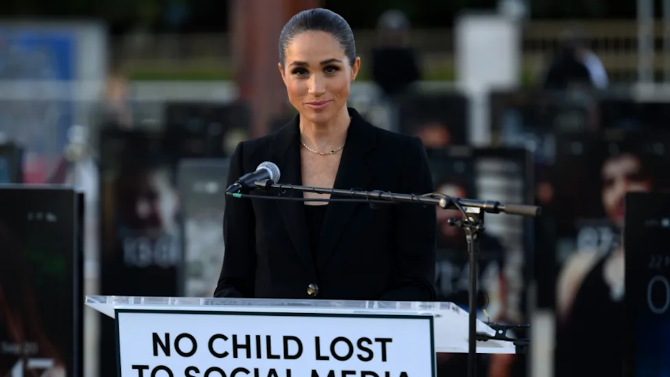 Meghan Markle speaking at a podium at an outdoor event