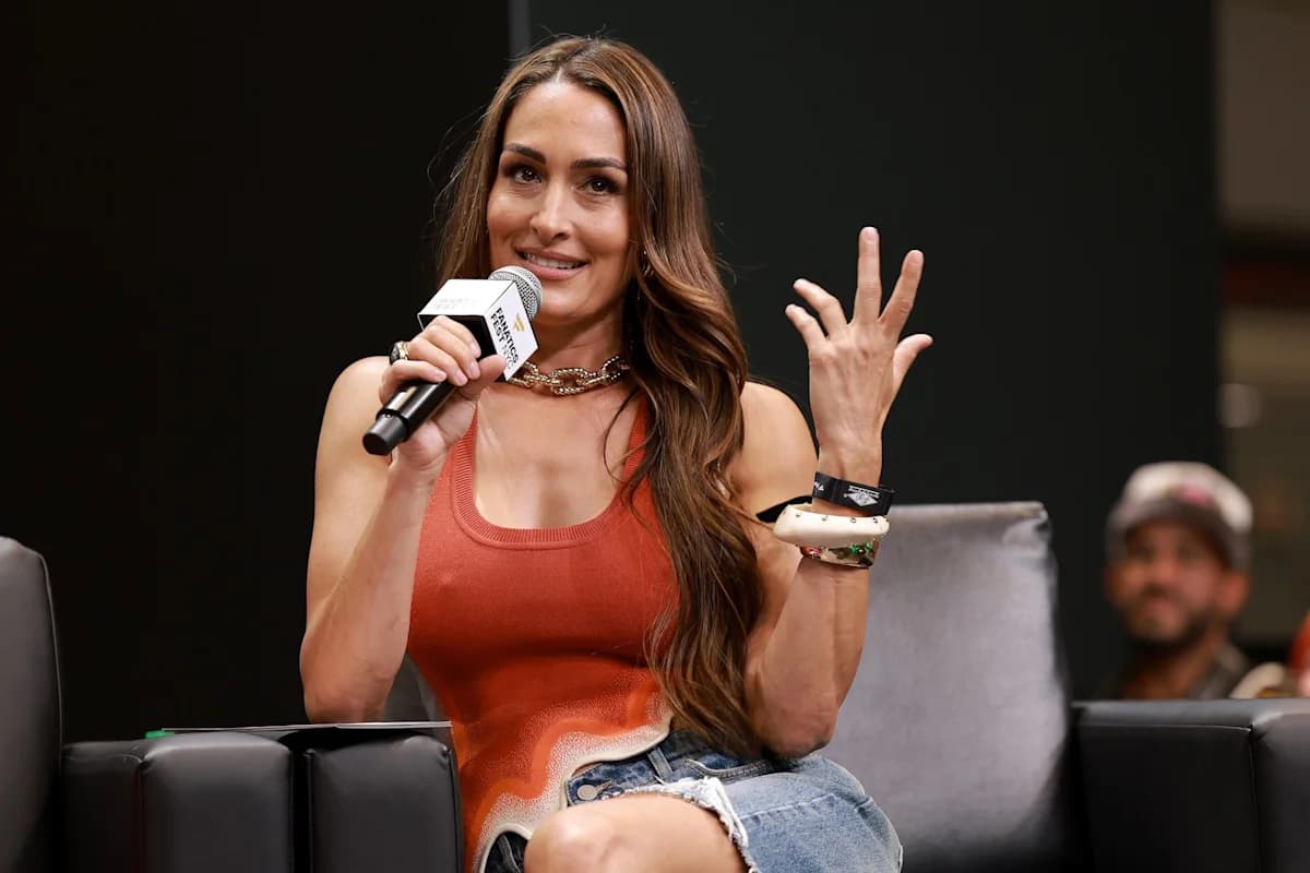 Nikki Garcia speaking into a microphone during a panel appearance