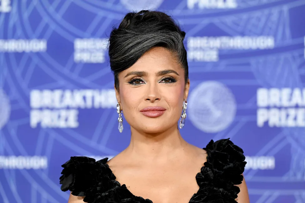 Salma Hayek at a red carpet event in a black ruffled dress