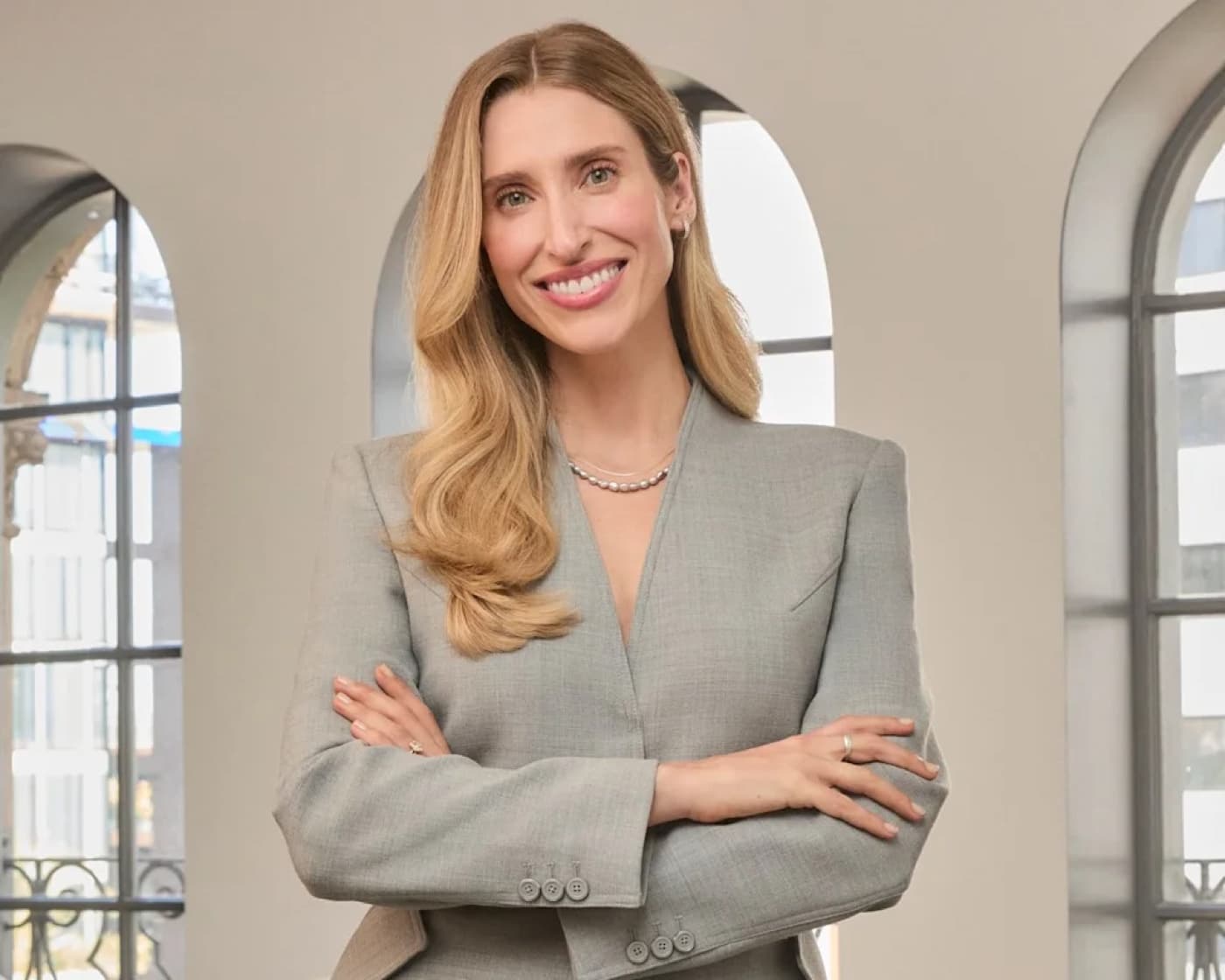 Dr Samantha Ellis smiling in a grey blazer with her arms crossed