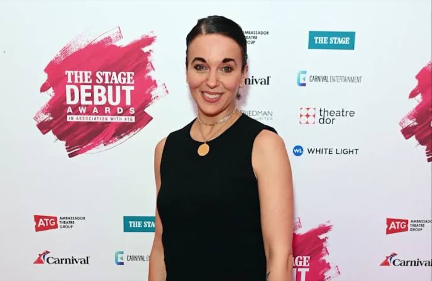Amanda Abbington smiling in a black dress at a red carpet event