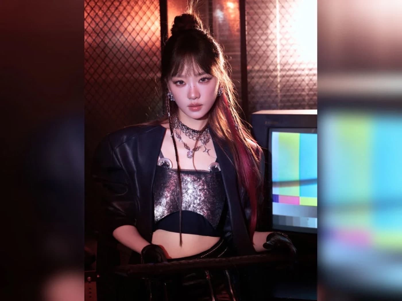Zhang Yue in a black leather jacket and sequined top against a moody lit backdrop