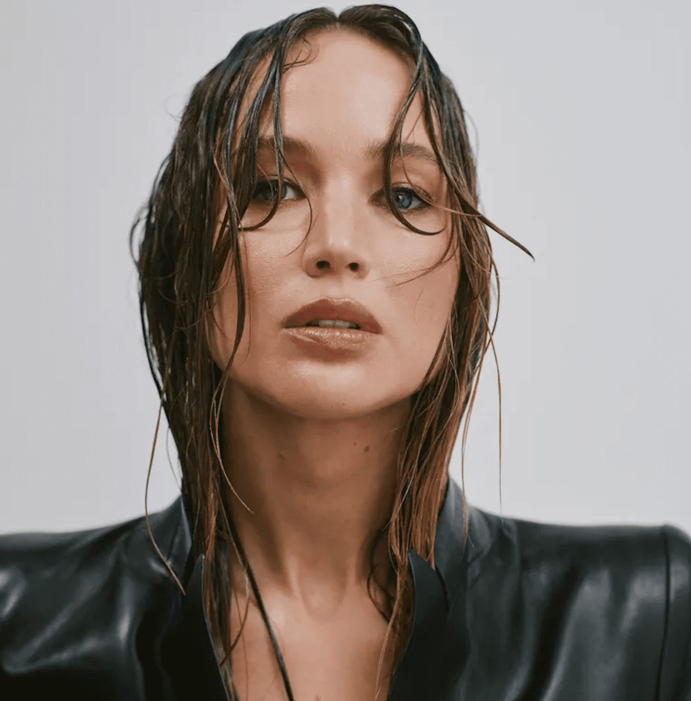 Jennifer Lawrence with wet, tousled hair in a black leather blazer for a mes° campaign portrait