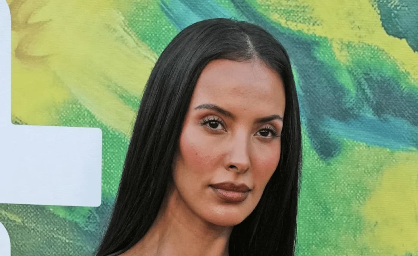 Maya Jama with straight dark hair against a green and yellow painted backdrop
