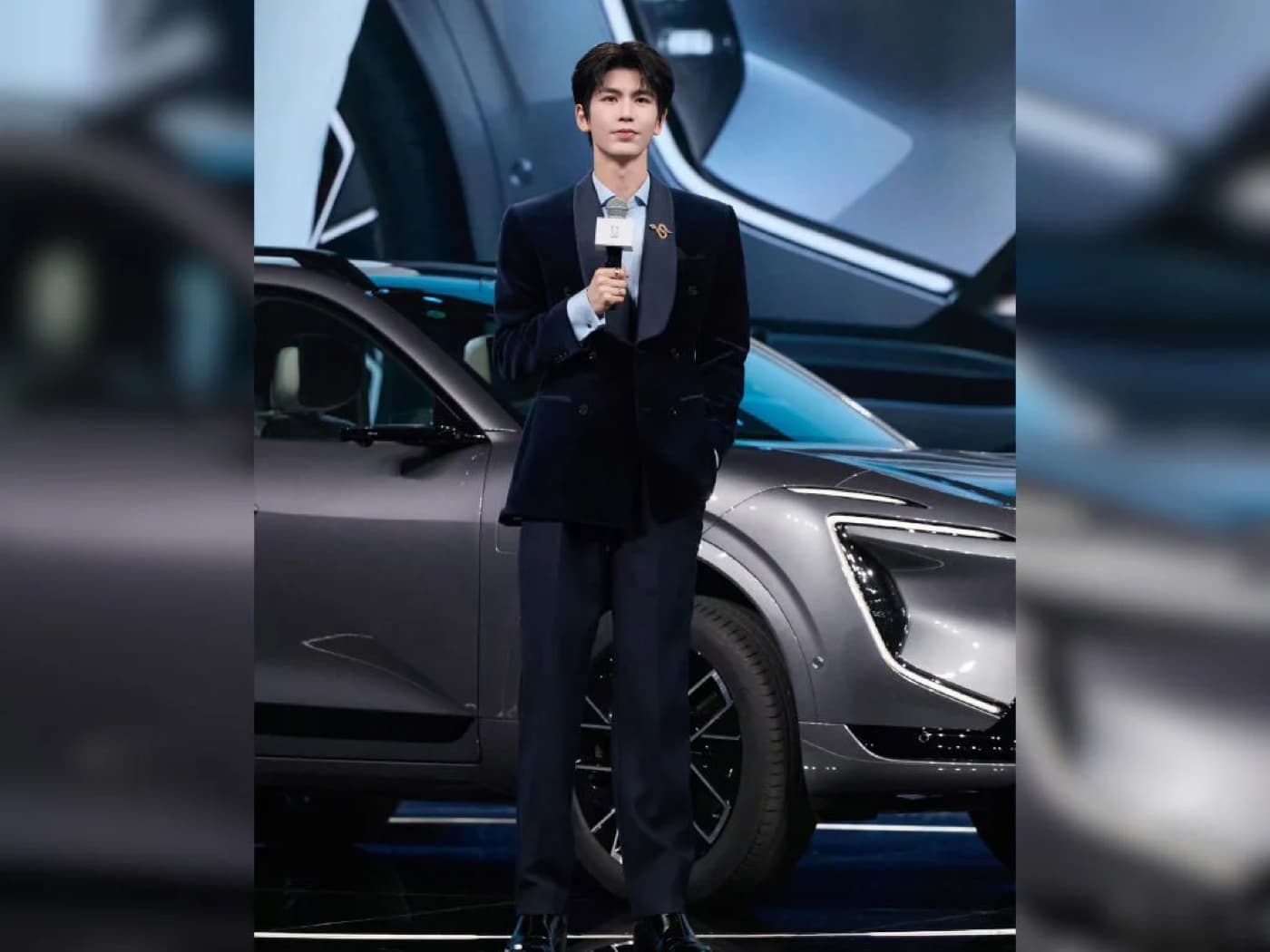 Zhang Linghe in a navy suit standing beside the Avatr 07L SUV