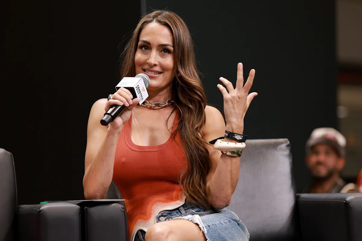 Nikki Garcia speaking into a microphone during a panel appearance